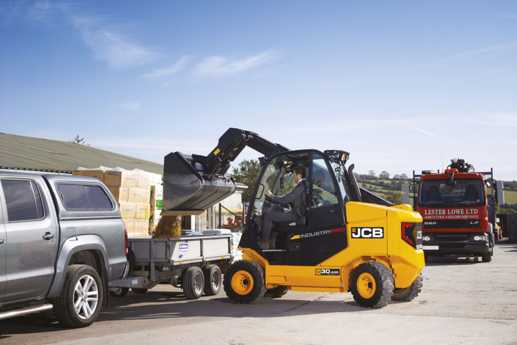 Teletruk operating in yard emptying materials into trailer