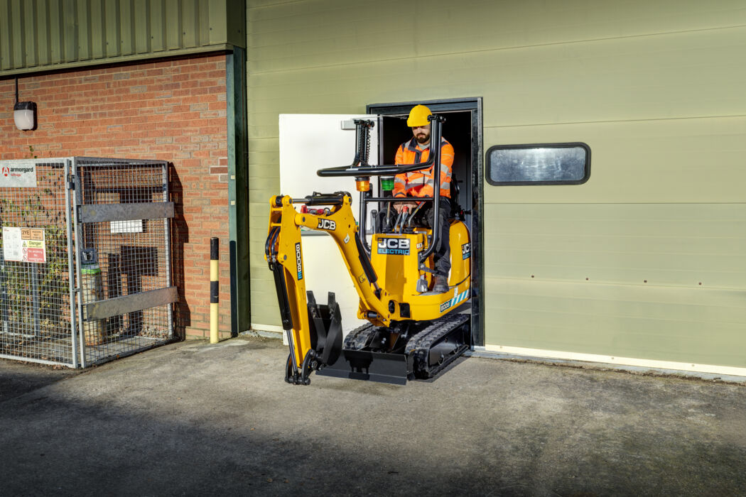 JCB 8008E micro excavator tracking through a tight doorway. 